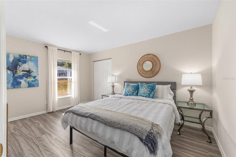 Guest bedroom with queen bed and sunburst mirror